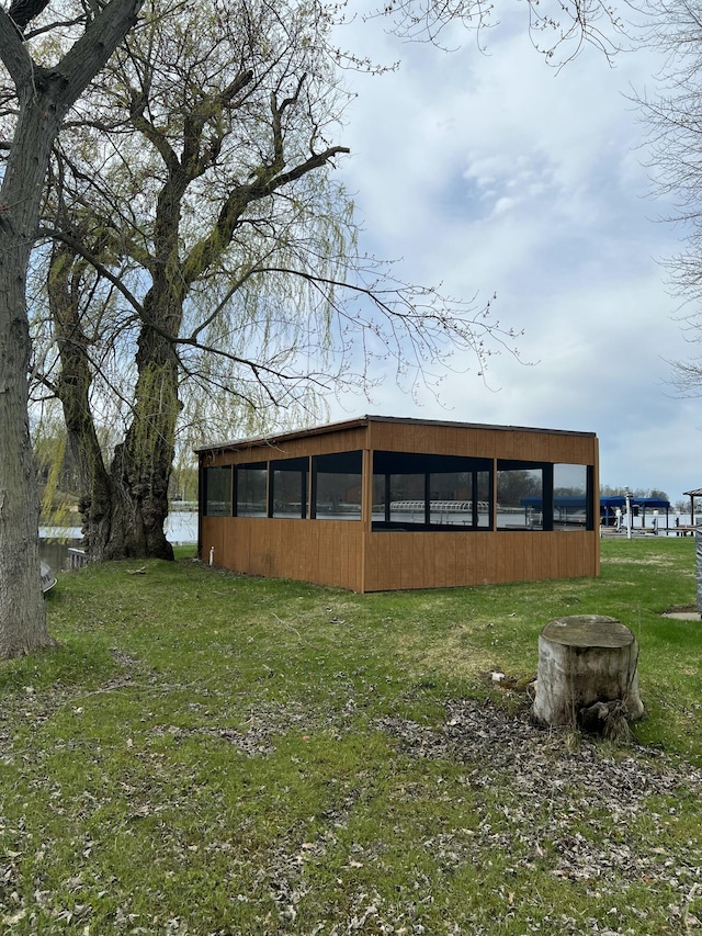 back of house with a pole building and a yard