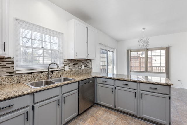 30701 Sandalwood Cir, Novi, MI 48377 - kitchen featuring stainless steel dishwasher, a sink, a peninsula, a notable chandelier, and gray cabinets
