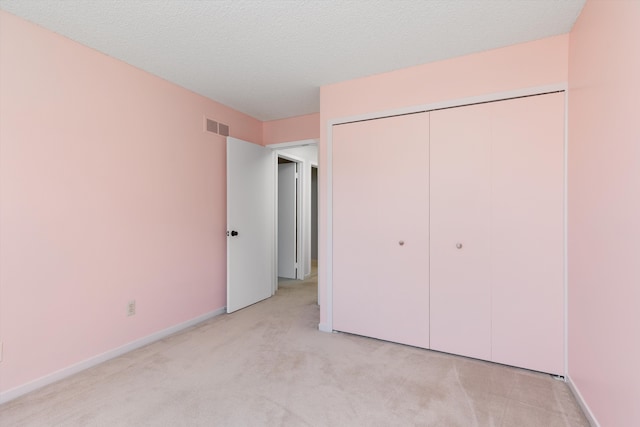 30701 Sandalwood Cir, Novi, MI 48377 - unfurnished bedroom featuring light colored carpet, a closet, baseboards, visible vents, and a textured ceiling