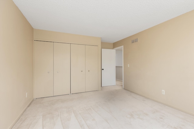 30701 Sandalwood Cir, Novi, MI 48377 - unfurnished bedroom with visible vents, a textured ceiling, a closet, and carpet