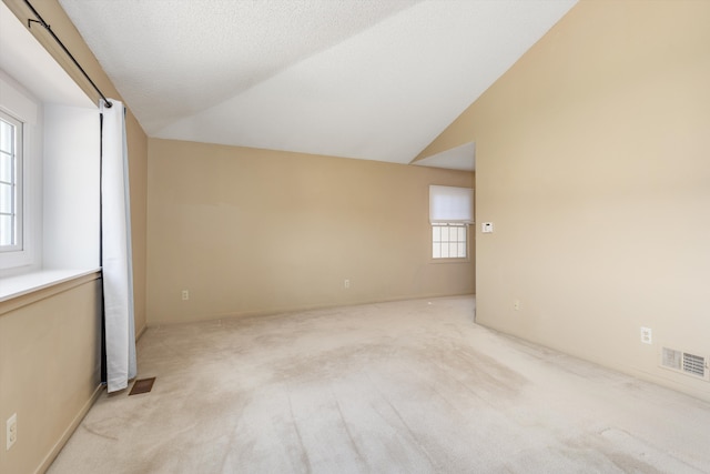 30701 Sandalwood Cir, Novi, MI 48377 - empty room featuring lofted ceiling, visible vents, and light colored carpet