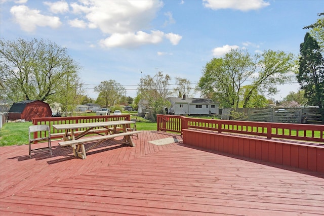 wooden deck with a storage shed, an outbuilding, and a fenced backyard