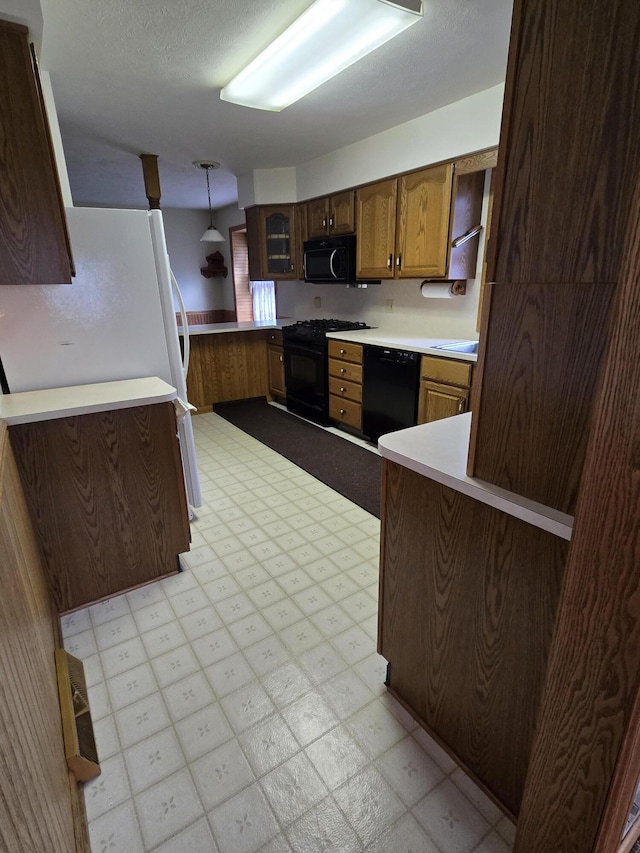 609 1st St, Lake Odessa, MI 48849 - kitchen featuring black appliances, decorative light fixtures, light countertops, and light floors