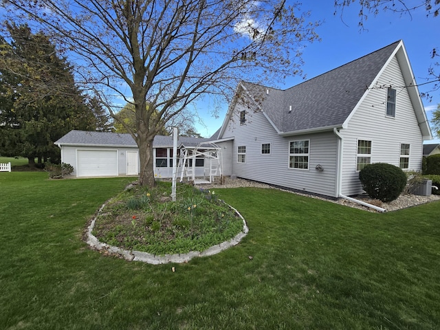 609 1st St, Lake Odessa, MI 48849 - back of house featuring roof with shingles, a yard, central AC, and a sunroom