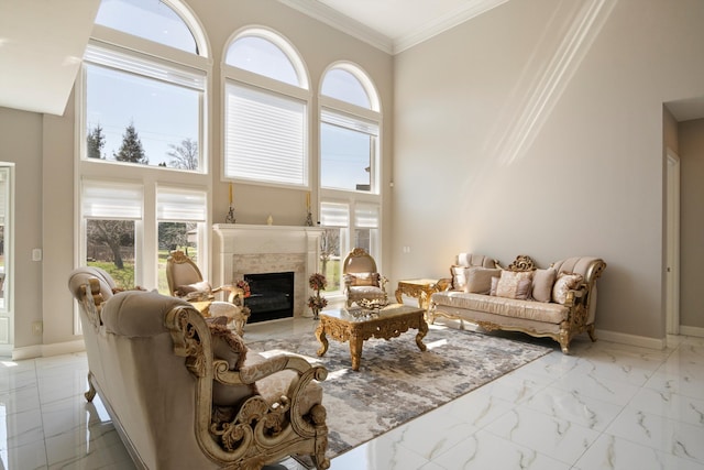 living area with crown molding, marble finish floor, baseboards, and a fireplace