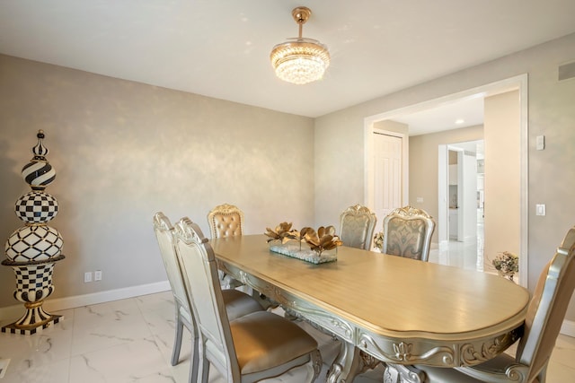 dining area with an inviting chandelier, visible vents, marble finish floor, and baseboards
