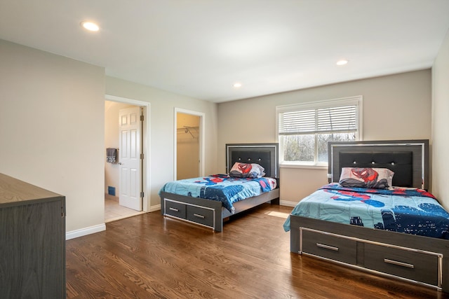 bedroom featuring recessed lighting, a spacious closet, wood finished floors, and baseboards