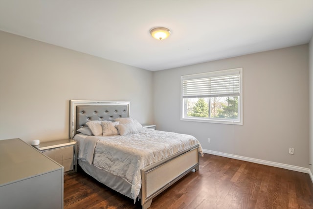 bedroom with dark wood finished floors and baseboards