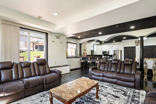 living area with visible vents, decorative columns, recessed lighting, and baseboards