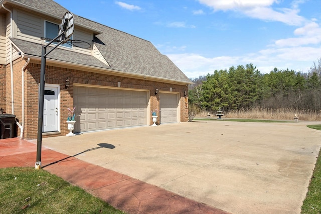 view of home's exterior featuring concrete driveway, roof with shingles, and brick siding