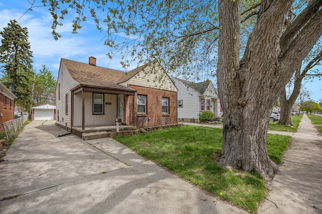bungalow-style house with a chimney, a shingled roof, an outbuilding, a front yard, and a porch