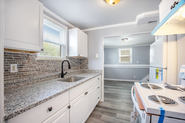 kitchen featuring white cabinets, light wood finished floors, a sink, white range with electric stovetop, and crown molding