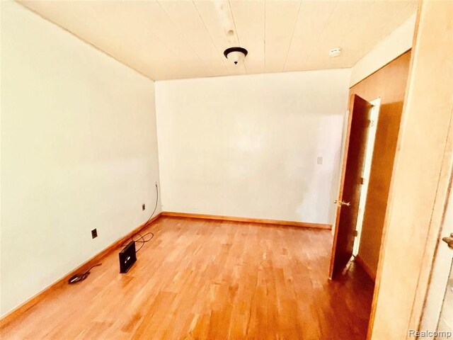 empty room with light wood-style flooring and baseboards