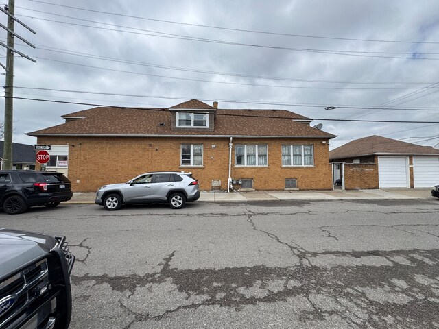 townhome / multi-family property with brick siding and a shingled roof