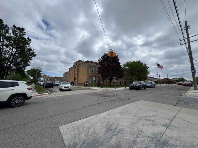 view of asphalt road with traffic signs, curbs, and sidewalks