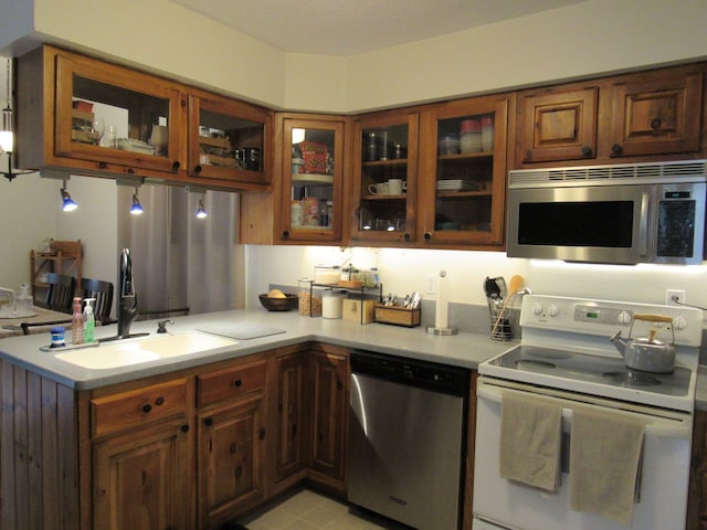 117 Vista Ct, Roscommon, MI 48653 - kitchen featuring light countertops, stainless steel appliances, glass insert cabinets, and a sink