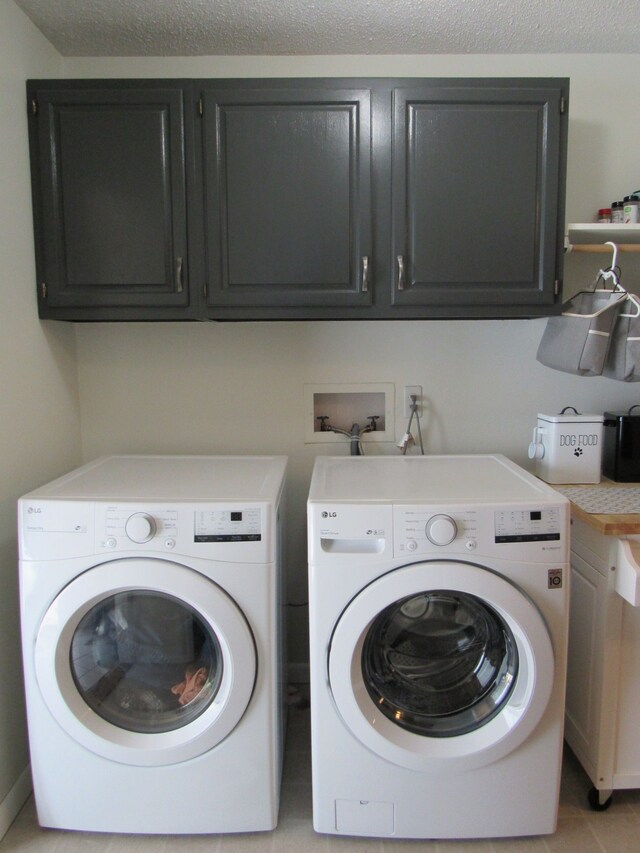117 Vista Ct, Roscommon, MI 48653 - laundry room featuring cabinet space, a textured ceiling, and washer and clothes dryer