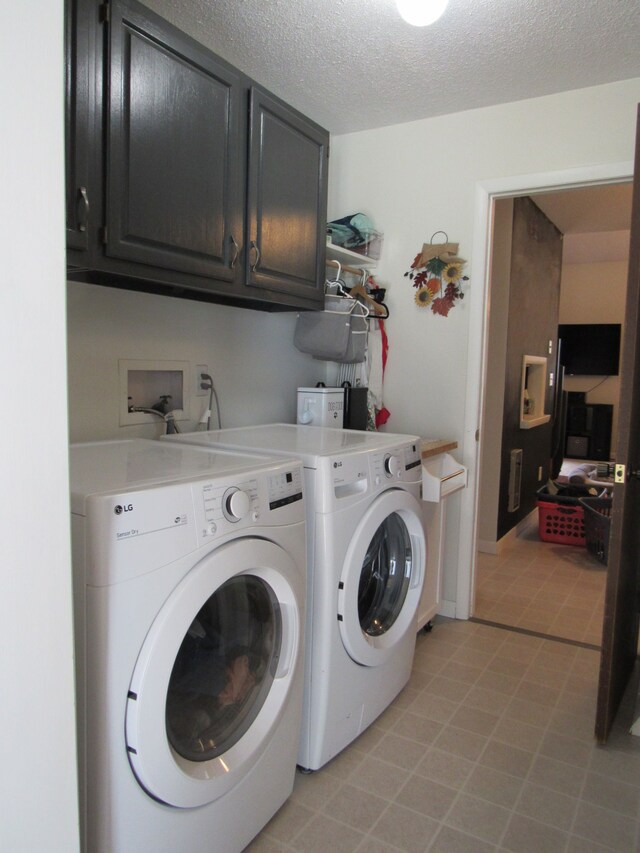 117 Vista Ct, Roscommon, MI 48653 - clothes washing area featuring washer and clothes dryer, cabinet space, and a textured ceiling