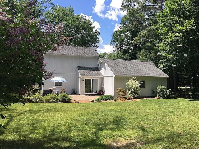117 Vista Ct, Roscommon, MI 48653 - back of house with a lawn, a shingled roof, and a patio area