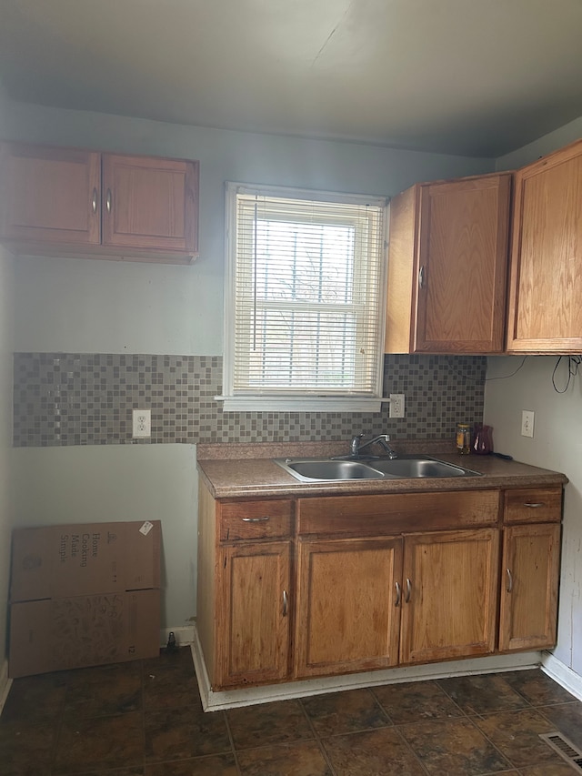 19483 Meyers Rd, Detroit, MI 48235 - kitchen with a sink, decorative backsplash, and brown cabinets