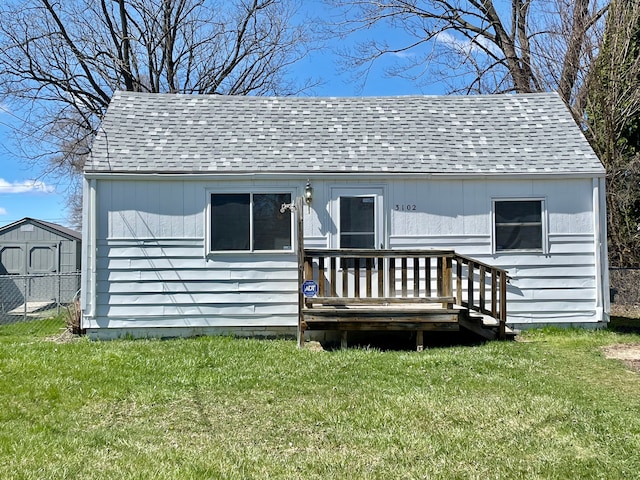 3102 Ludwig St, Burton, MI 48529 - back of house with a lawn, an outbuilding, a shingled roof, and a deck