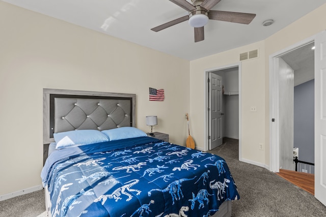 25820 Lord Dr, Chesterfield, MI 48051 - carpeted bedroom with a walk in closet, visible vents, ceiling fan, and baseboards