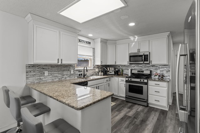 25820 Lord Dr, Chesterfield, MI 48051 - kitchen with white cabinets, stainless steel appliances, a peninsula, and a sink