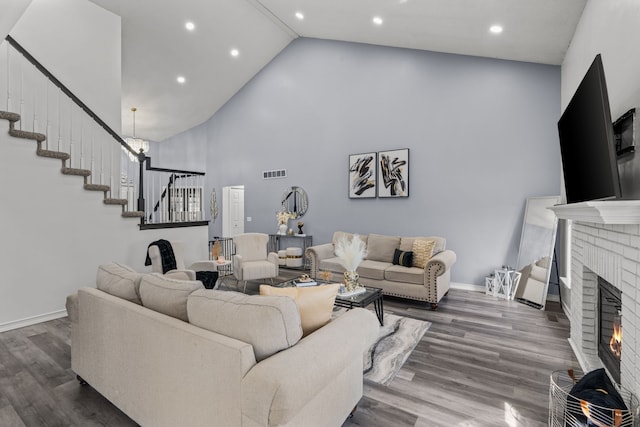 25820 Lord Dr, Chesterfield, MI 48051 - living room with stairway, visible vents, a fireplace, wood finished floors, and high vaulted ceiling