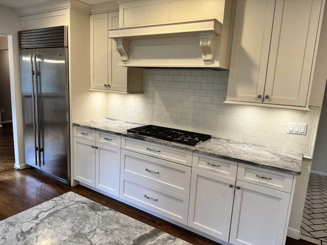 35315 Regency Ln, Farmington Hills, MI 48331 - kitchen with built in fridge, gas cooktop, wall chimney range hood, and light stone counters