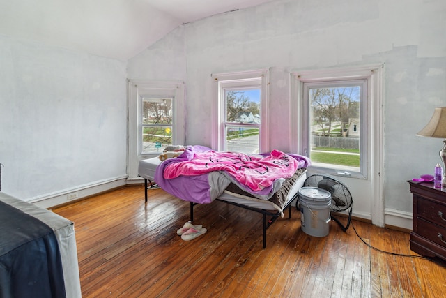 2602 Gratiot Ave, Port Huron, MI 48060 - bedroom with multiple windows, vaulted ceiling, hardwood / wood-style flooring, and baseboards