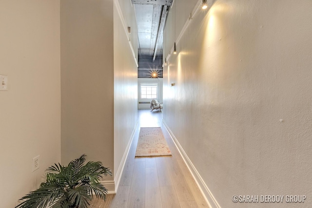 hallway featuring hardwood / wood-style floors and baseboards