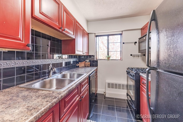 kitchen featuring a sink, tasteful backsplash, black appliances, reddish brown cabinets, and dark tile patterned floors