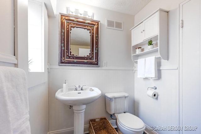 half bathroom with visible vents and toilet