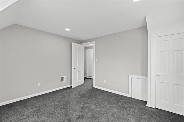 unfurnished bedroom featuring dark carpet, recessed lighting, baseboards, vaulted ceiling, and visible vents