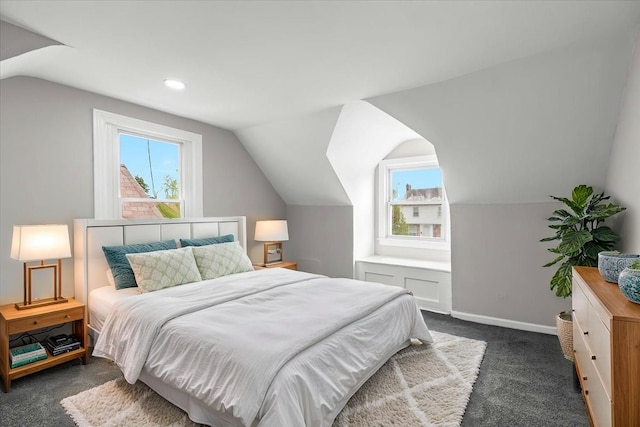 bedroom with baseboards, dark colored carpet, and lofted ceiling