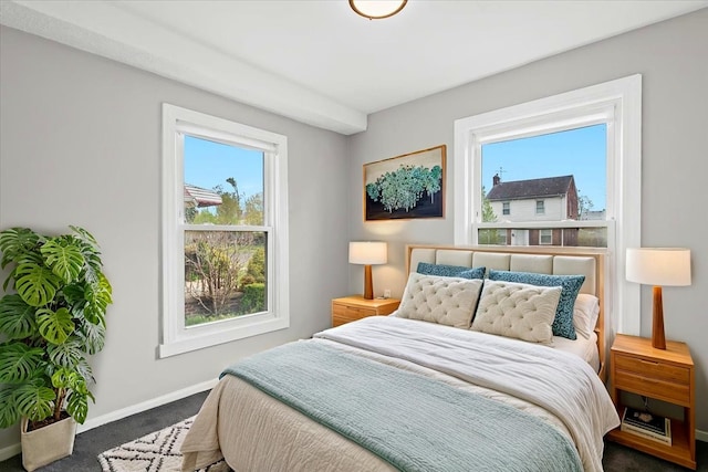 bedroom featuring carpet floors, multiple windows, and baseboards