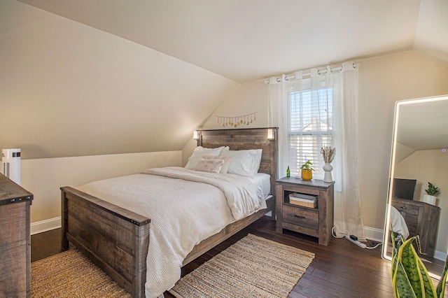 bedroom featuring baseboards, hardwood / wood-style floors, and lofted ceiling