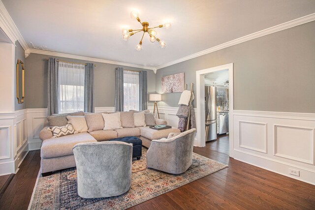 living room with crown molding, a wainscoted wall, and a notable chandelier