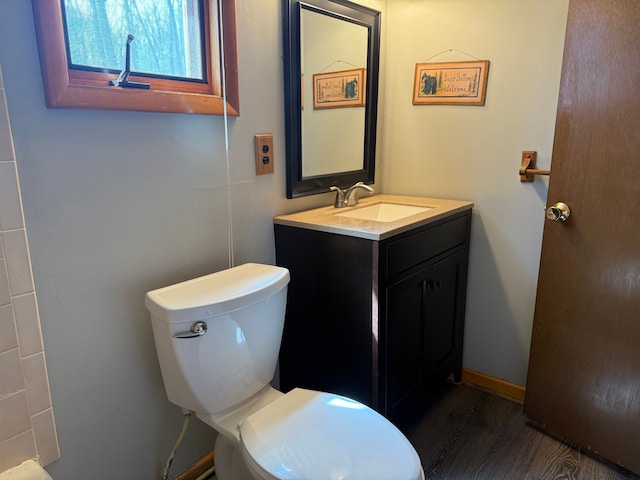 bathroom featuring toilet, wood finished floors, and vanity