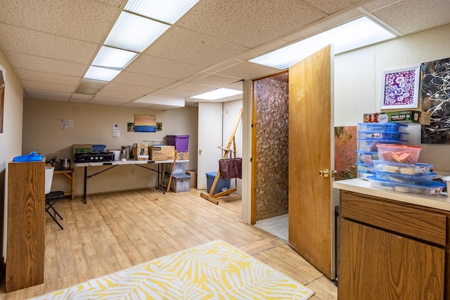 office with a drop ceiling and light wood-type flooring