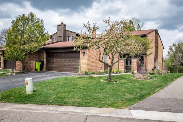 view of front facade with a garage, driveway, a front lawn, and brick siding