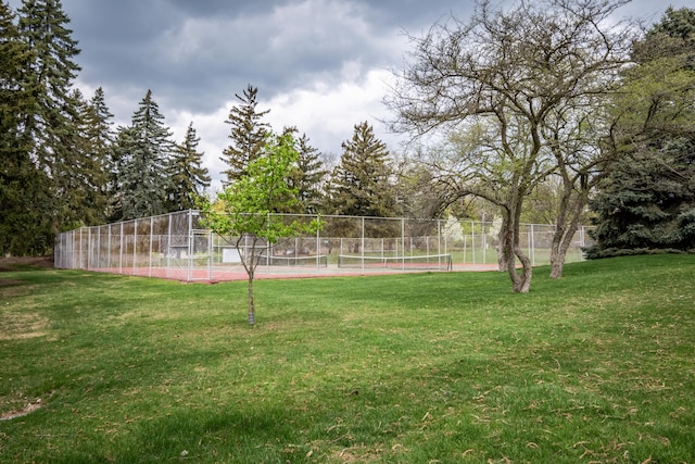 view of yard with a tennis court and fence