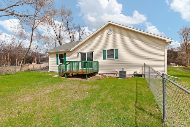 back of property with a lawn, a deck, a fenced backyard, and central AC unit