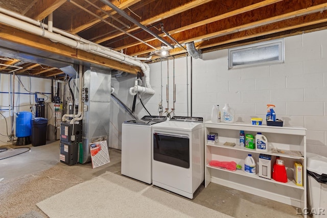 washroom with heating unit, gas water heater, laundry area, and independent washer and dryer