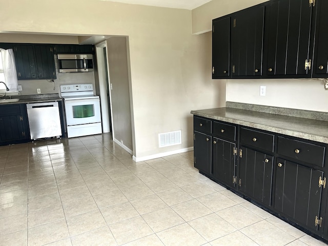 kitchen featuring dark cabinetry and appliances with stainless steel finishes