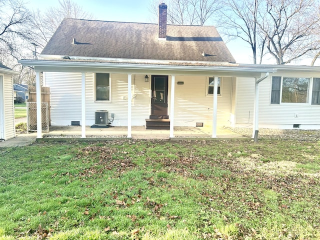 rear view of house featuring crawl space, a patio area, a yard, central AC, and a chimney