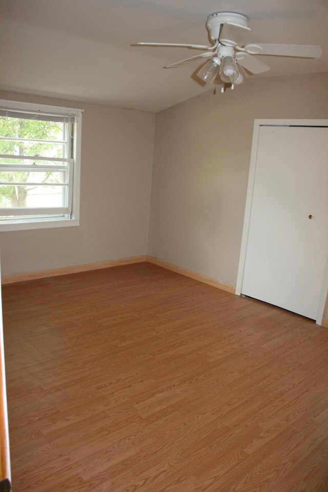 unfurnished room featuring baseboards, a ceiling fan, and light wood-style flooring