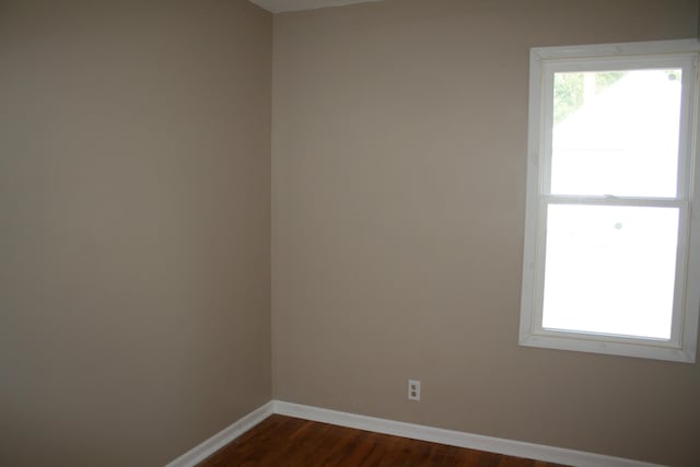 empty room featuring dark wood finished floors and baseboards