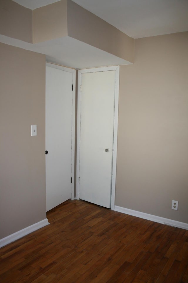 unfurnished room featuring baseboards and wood finished floors