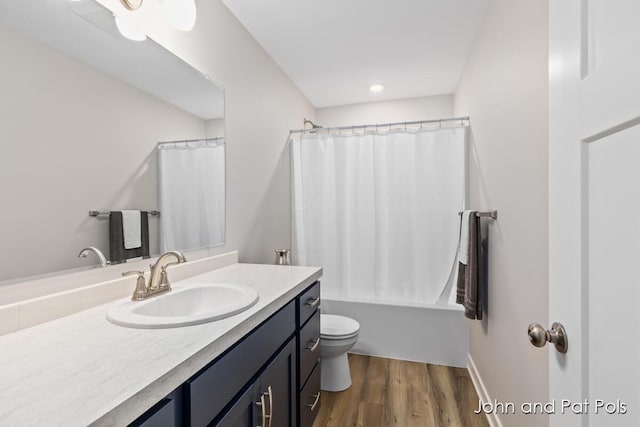 full bathroom featuring toilet, wood finished floors, vanity, and shower / bath combination with curtain